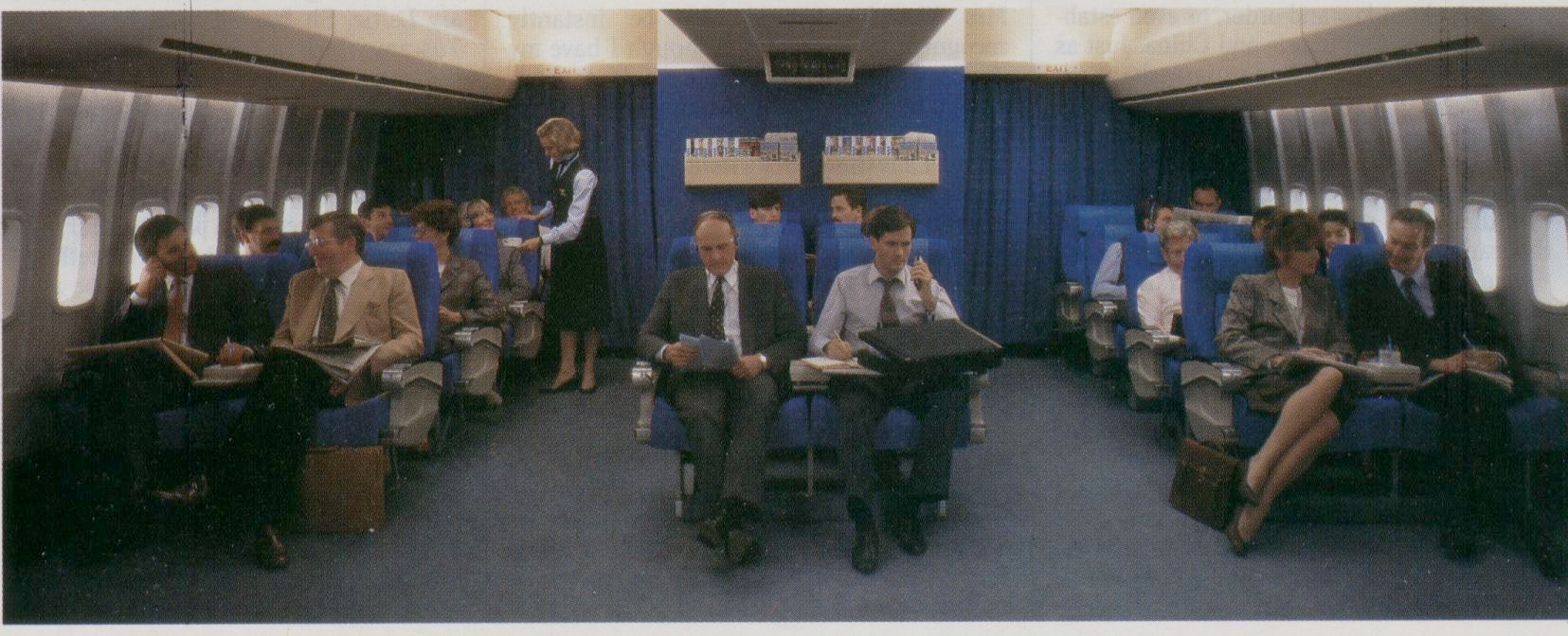 1986 When Pan Am converted the Clipper Class (Business Class) cabin from 8 across to 6 across seating bright blue seat covers were adopted as seen in this photo.  In 1988 Pan Am converted the business class  seat covers to a more demure herringbone pattern.